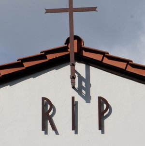 Helle Kapelle mit rotem Dach mit Aufschrift RIP
