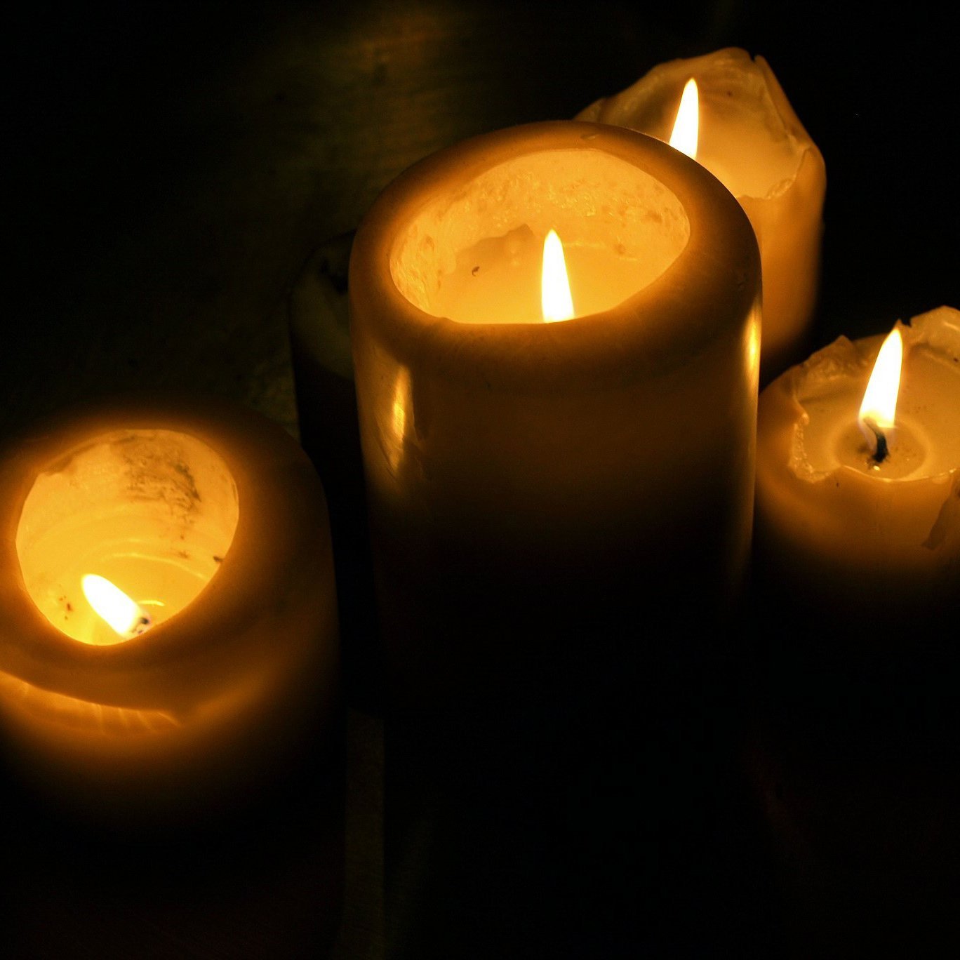 Vier brennende Kerzen in der Dunkelheit