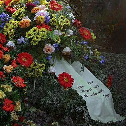 Blumen und Kranz auf einer Grabstelle