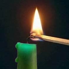 Grüne Kerze wird mit Streichholz angezündet
